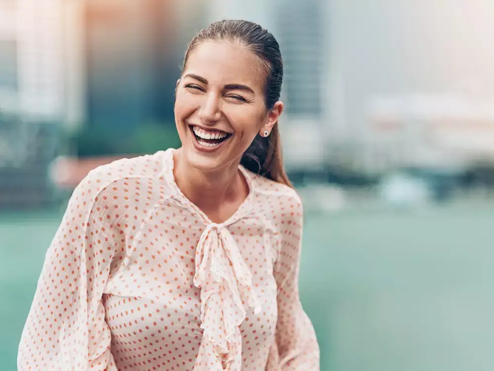 A woman in a blouse smiling widely